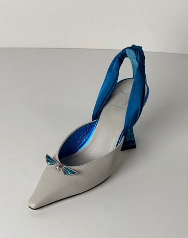 Judy Mazzotti pair of shoes with a blue ribbon tied to a shoe