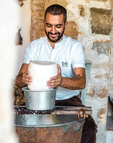 Sardinian cheesemaker shaping fresh cheese inside a traditional copper cauldron