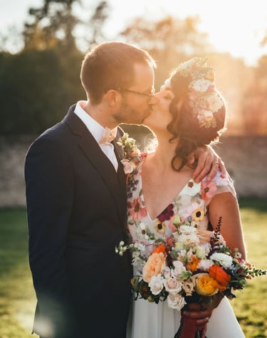 couple de mariés s'embrassant avec bouquet