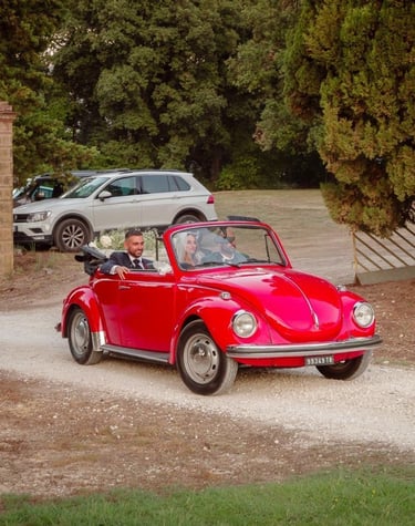 Maggiolone d'epoca con gli sposi a bordo che parte dalla chiesa per dirigersi verso la villa.