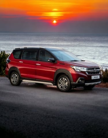 a red Suzuki xl6 parked on a road near the ocean
