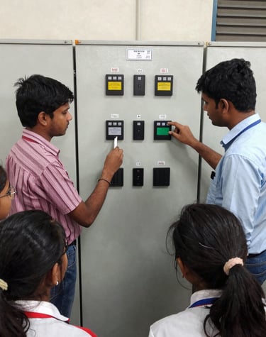 Students working intently on a PLC programming setup in a modern lab.
