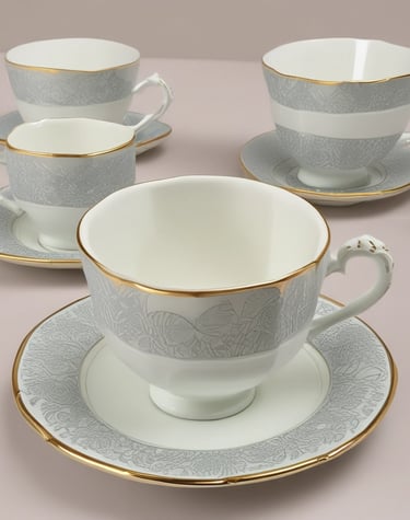 A cozy display of ceramic mugs and cups on a wooden shelf.