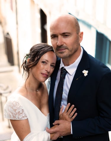 couple de mariés qui se prennent dans les bras en regardant l'objectif