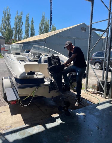 Mobile marine technician changing gear oil on a stern drive.