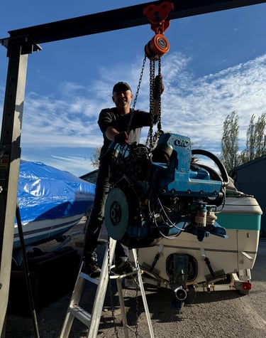 Mechanic fixing an outboard motor electrical issue at a marina in St. Catharines.