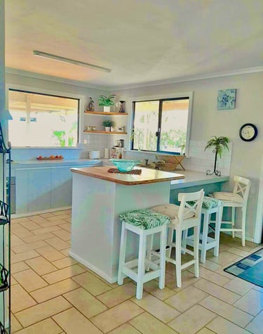 a kitchen with a large island bench and views!