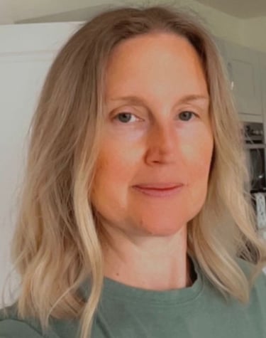 Profile of a middle aged woman with short blonde hair wearing a green t-shirt