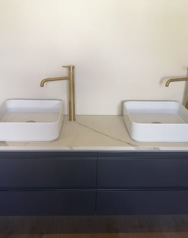 meuble bleu de salle de bain, vasques à poser carrées, robinetterie bronze grand bec.