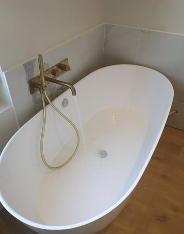 Baignoire ilot, robinetterie bronze encastrée, faïence marbre blanc.