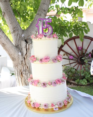 Tarta de cumpleaños elegante con flores naturales en tonos rosas, creada en Madrid