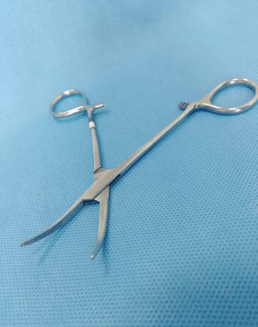 Pinça Kelly curva sobre tecido azul estéril, usada para pinçar vasos e tecidos.