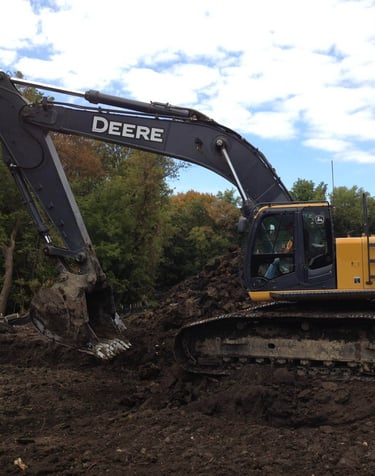 John Deere Excavator digging up dirt