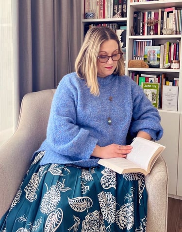 Julie Mitrovic sitting reading a book, Positive Psychology & embodiment coach