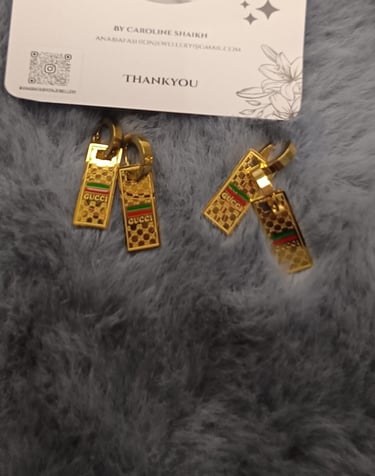 a pair of earrings with gold and silver