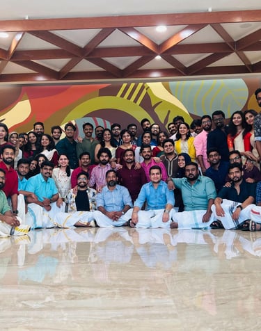 A large group of colleagues posing in traditional Indian attire during a corporate office celebration.