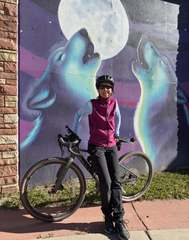 The author posing with her Canyon bike in front of a wolf mural