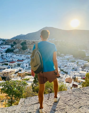 a man watching down on lindos village in rhodes