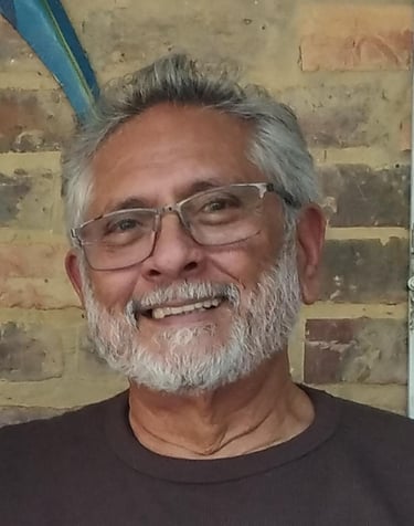 a man with a beard and glasses on a brick wall