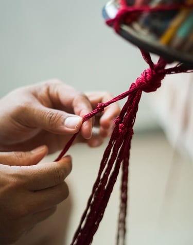 Estudiante aprendiendo nudos básicos para una pieza artesanal de macramé.