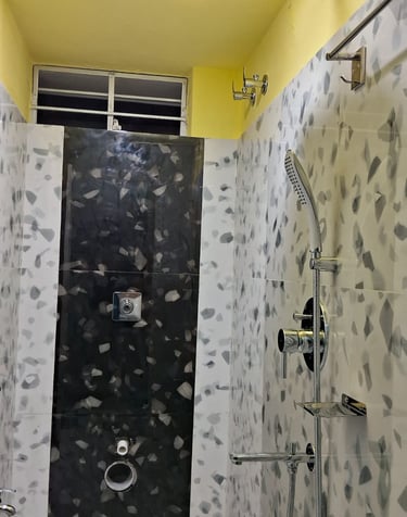 A bathroom with white tiles and a shower and window on top