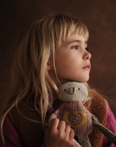 a young girl holding a stuffed animal