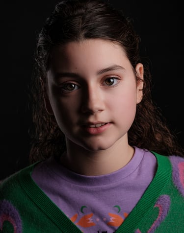 a young girl with a green sweater and a purple sweater