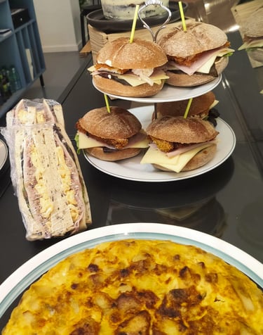 Un mostrador con tortilla, sandwich y bocadillo sin gluten