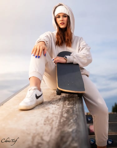 Photo d'un jeune femme en tenue de sport assise avec son skateboard au skatepark de Perpignan 66.