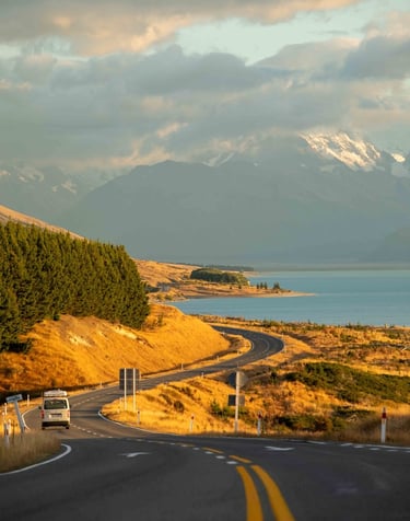camper van driving on road near sunset