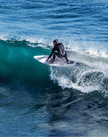a man in a wetsuit surfing on a wave
