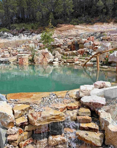 Natural pool waterfall with stream flowing through wetland into limestone swimming area - Aqua Vitae