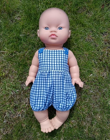 Minikane doll Rai dressed in blue gingham overalls