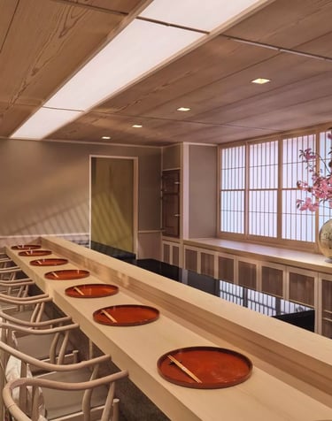 Minimalist sushi counter with traditional Japanese decor at an exclusive fine dining restaurant.