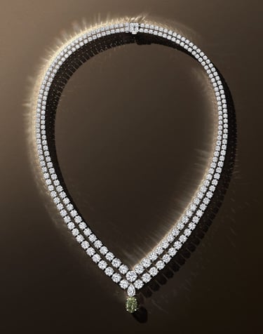 De Beers diamond necklace with green gemstone pendant.