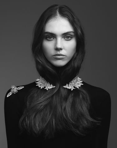 Model wearing leaf-shaped diamond jewelry on neckline and shoulder..