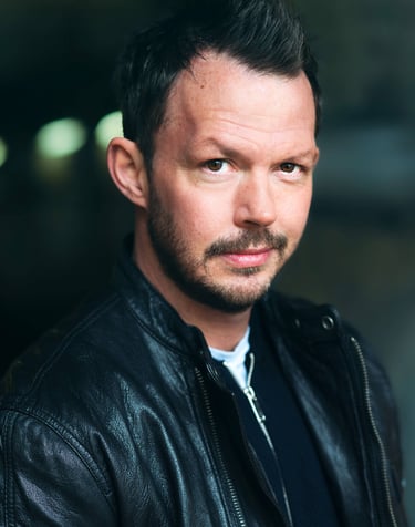 a man with a beard and a leather jacket