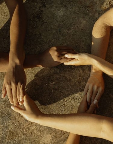 des personnes se tiennent les mains dans la nature au couché du soleil