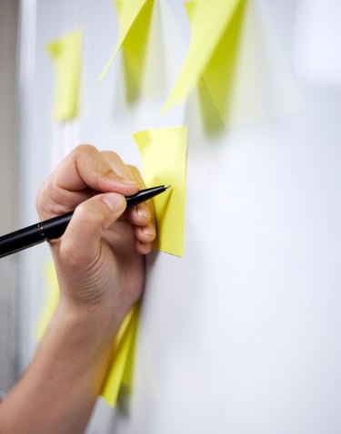Team of educators planning strategy, writing on whiteboard or desk with documents, educational project planning