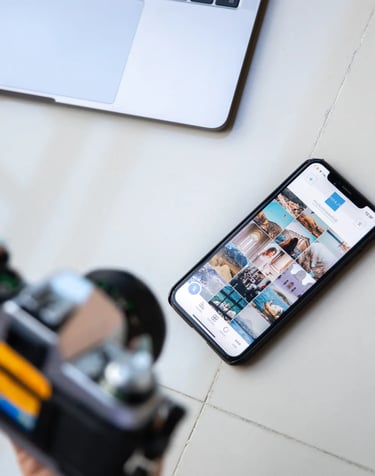 Osoba drži analognu kameru iznad pametnog telefona sa prikazom Instagram grida – vizuelni prikaz zna