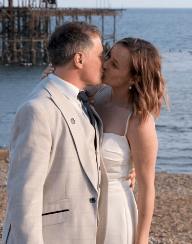 A bride and groom kissing on the beach