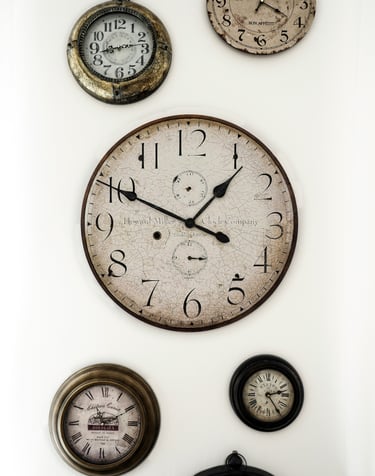 plusieurs vieilles horloges accrochées sur un mur et donnant des heures différenes. Unsplash.
