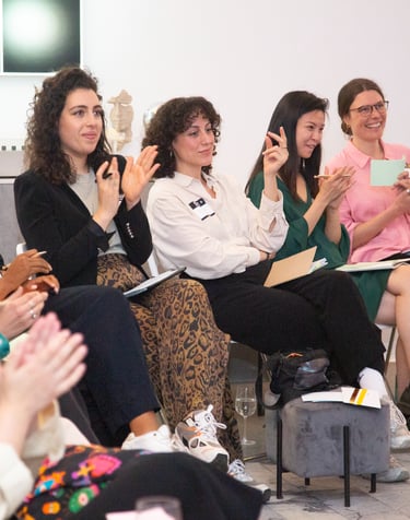 Women applauding for other women at public speaking workshop
