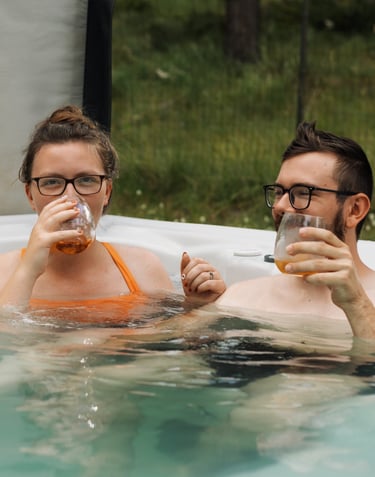 a man and woman in a hot tub drinking whiskey