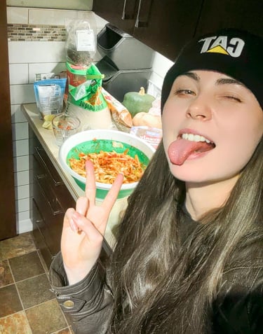 a woman with long hair and a hat on with her tongue stuck out in front of kimchi