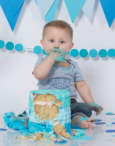 a baby boy in a blue birthday cake