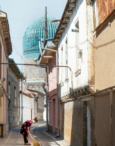 A girl is sweeping a narrow street in Tashkent
