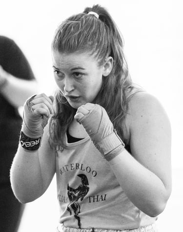 Jessica wearing handwraps with her hands up in a fighting position.