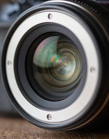 A macro photograph of a professional camera lens aperture, sharp focus, with subtle dusty seafoam color reflections.