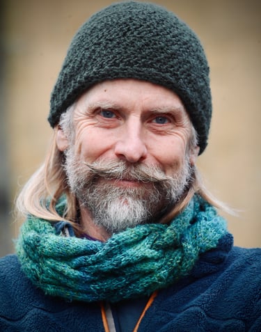 Portrait of narrative consultant, coach and facilitator, Dominic Weston, in woolly hat and scarf